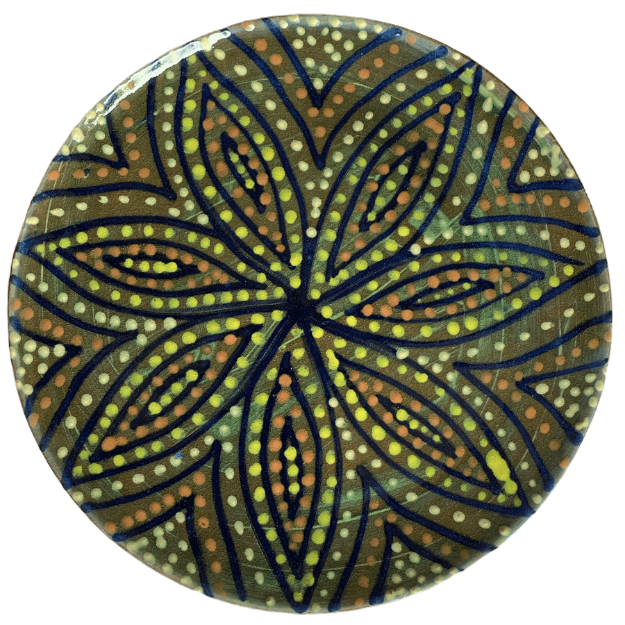 Pottery design with green background with a starburst of colorful crescents and dots.